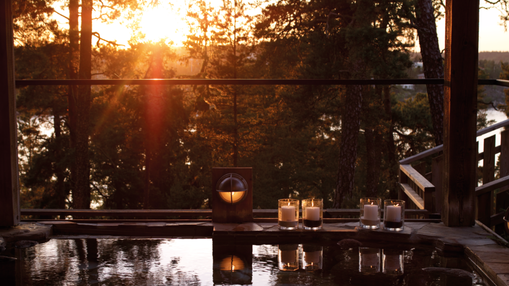 Yasuragi pool med utsikt över sjö och solnedgång.