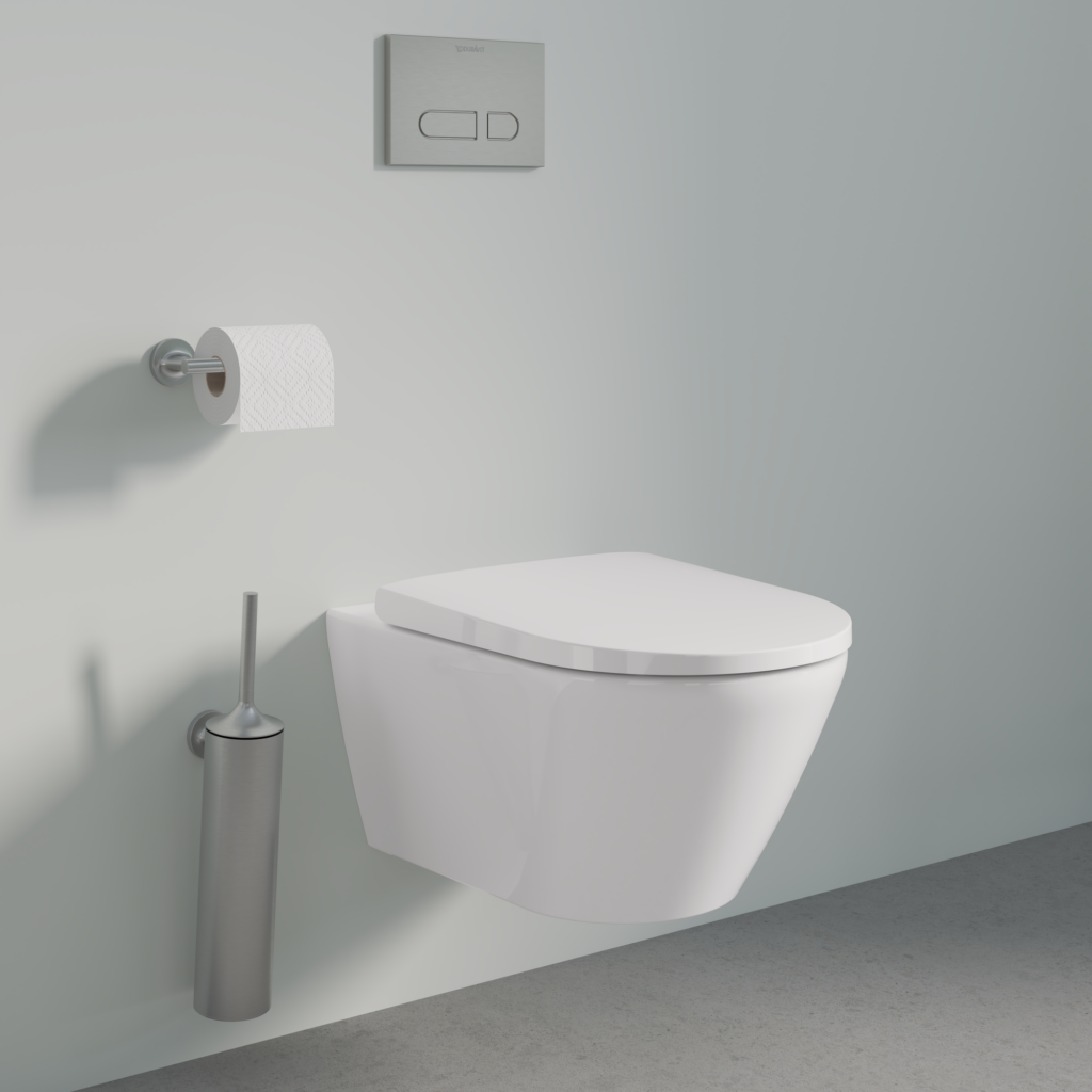 Badrum med toalett. Tillbehör som toalettborste, spolplatta och toalettpappershållare matchar i samma färg.