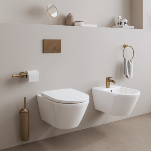 Badrum med toalett och bidé. Tillbehör som toalettborste, spolplatta och toalettpappershållare matchar i samma färg.