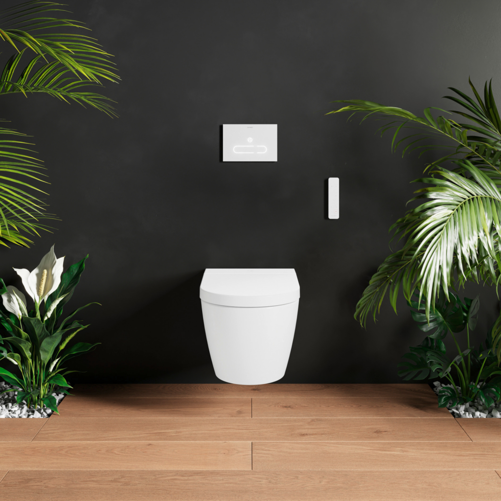 Starck f Plus SensoWash vägghängd toalett på en mörk vägg med växter runt om.
