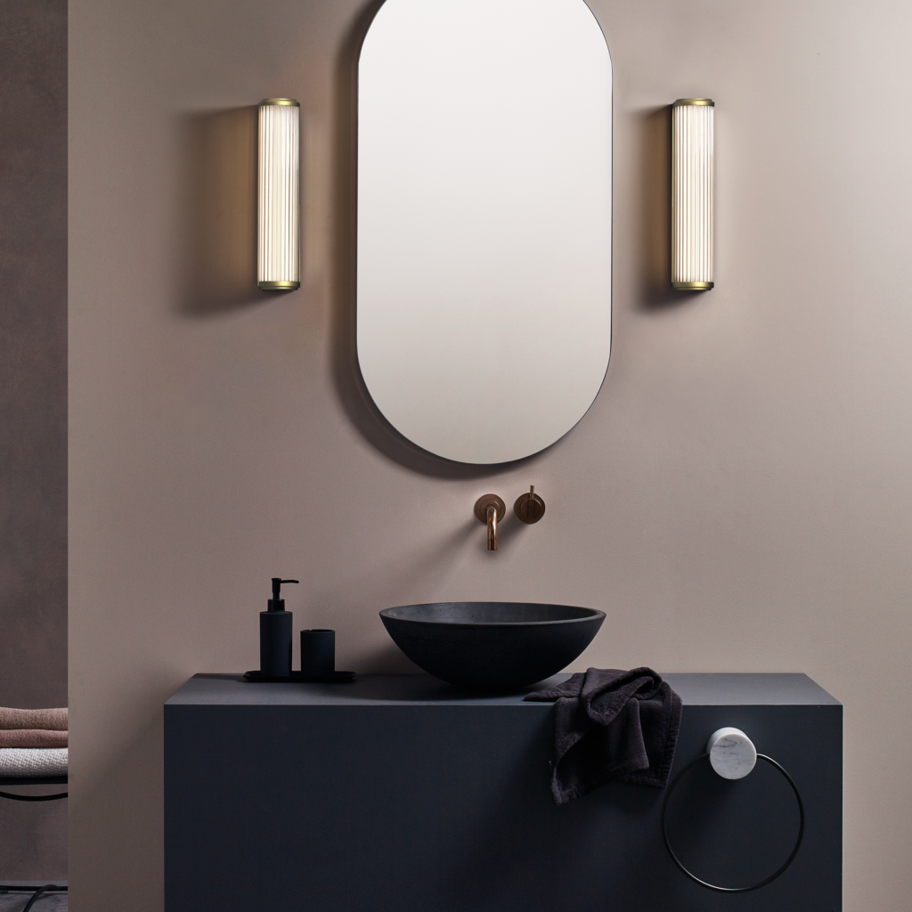 Versailles 370 LED sitter på en badrumsvägg på vardera sida om en spegel och över ett tvättställ.