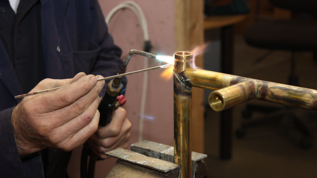 Man som löder ihop en handdukstork.