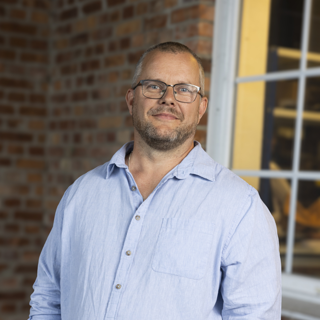 Man med skägg och glasögon.