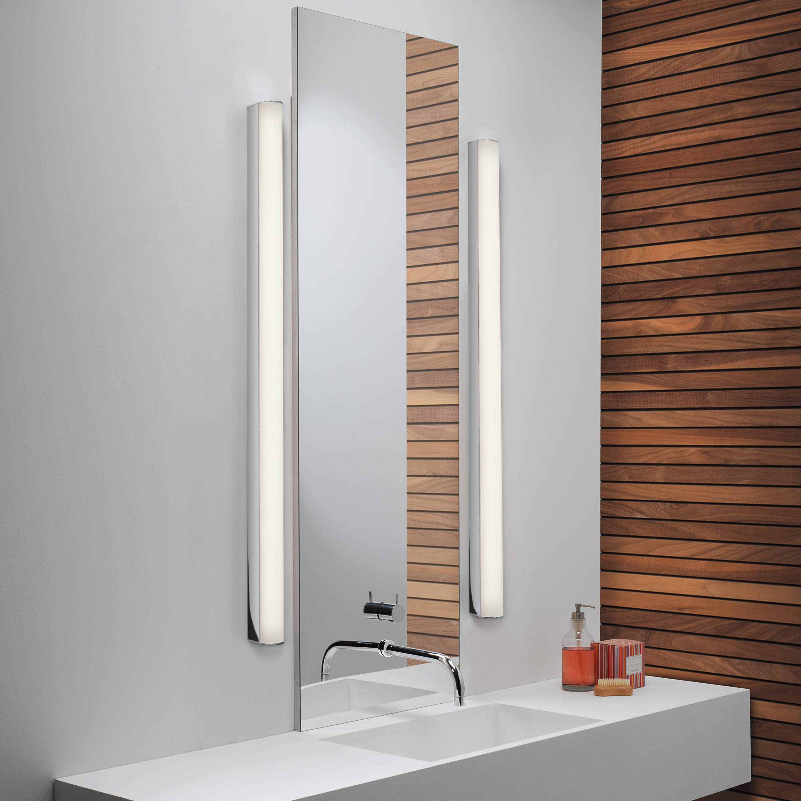 Artemis 900 LED vägglampa i ett badrum med rektangulär spegel och tvättställ.